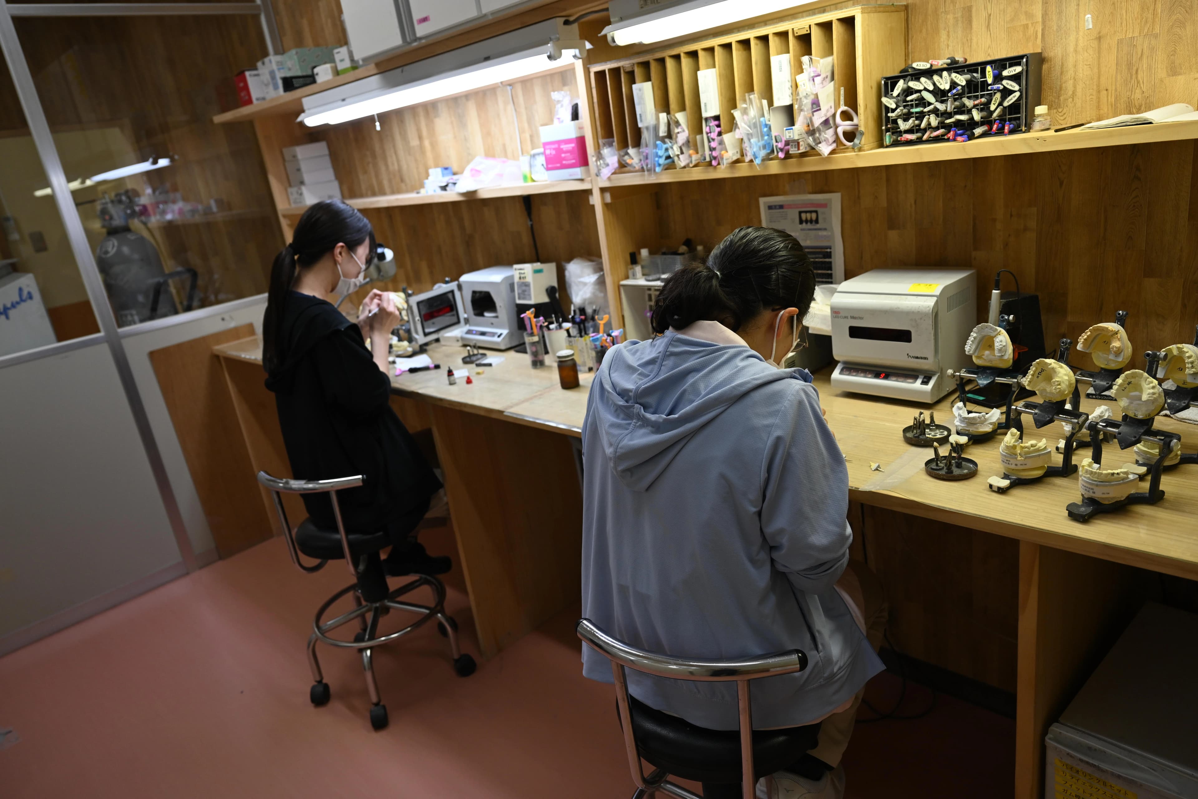 明るい作業室で技工物を仕上げる技工士たち