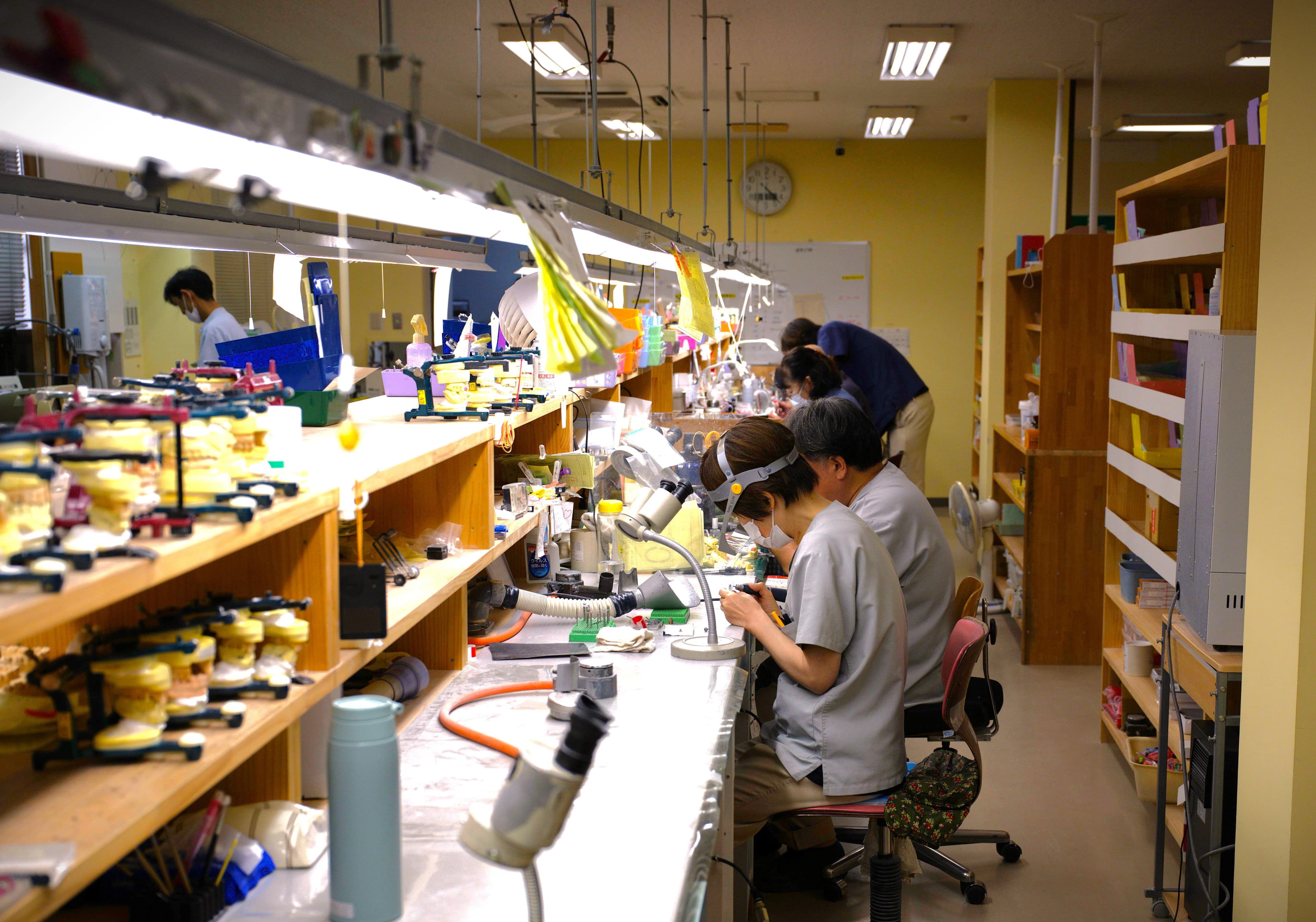 歯科技工所の作業室で技工物を製作する技工士たち